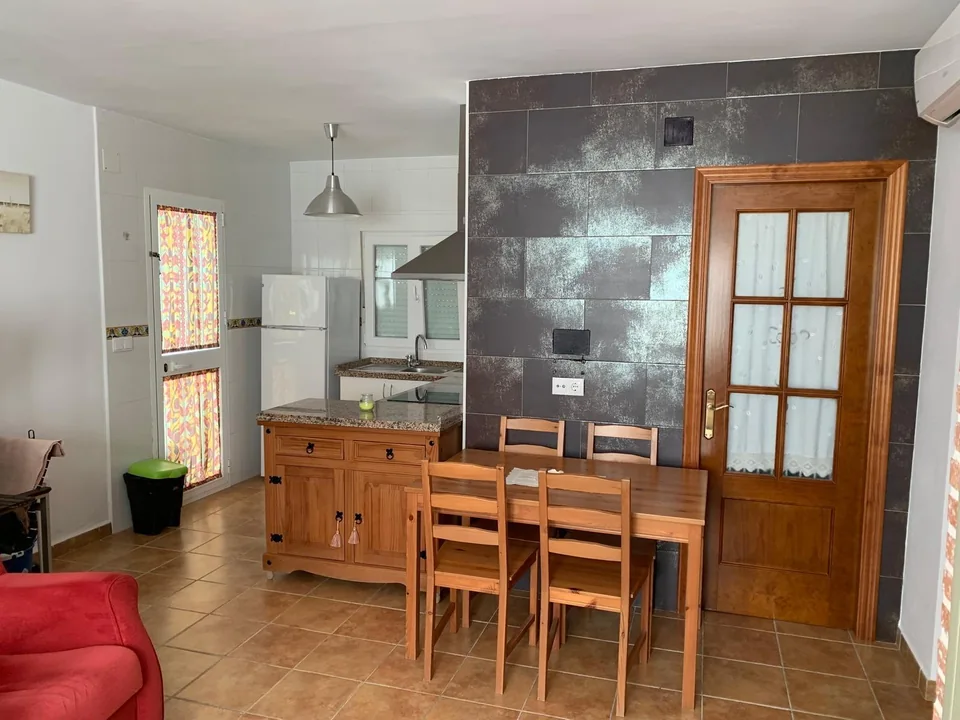 Cocina abierta y mesa de comedor de madera en Casa Poniente