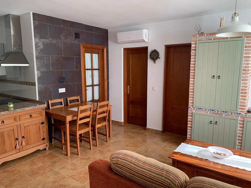 Mesa de comedor de madera entre la cocina y la zona de estar